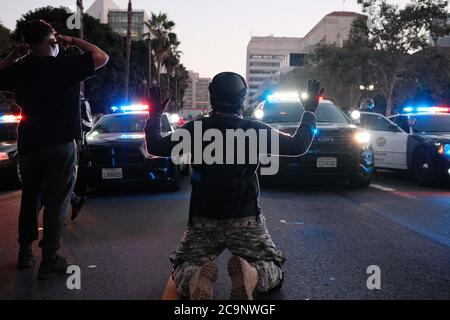 Protestor with hands up in front of the LAPD vehicles that were kettling them. Stock Photo