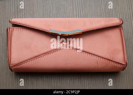 Small satin pink handbag on wooden background Stock Photo