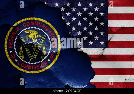 flags of Federal Communications Commission and USA painted on cracked wall Stock Photo