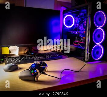 Game pad on a wooden desk with glass pc case on the background Stock Photo