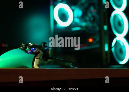 Close up of a game pad and a glass pc case with rgb lighting Stock Photo