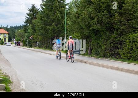 Zlatibor, Serbia - July 25. 2020 Cyclists ride bicycles down the street in a natural resort on Zlatibor Stock Photo