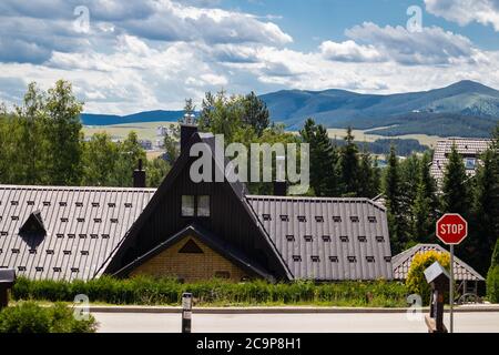 Zlatibor, Serbia - July 25. 2020 Roof from hotels and Stop street sign and mountain with a dramatic sky in background in a natural resort on Zlatibor Stock Photo