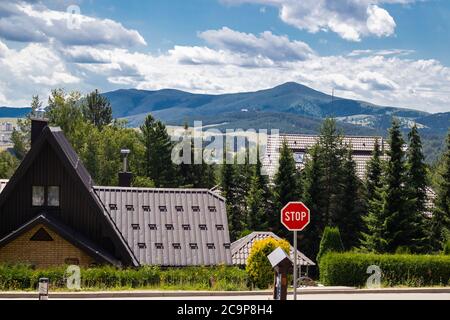 Zlatibor, Serbia - July 25. 2020 Roof from hotels and Stop street sign and mountain with a dramatic sky in background in a natural resort on Zlatibor Stock Photo