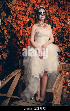 Woman with ghost make up and wedding dress on yellow leaves background Stock Photo Alamy