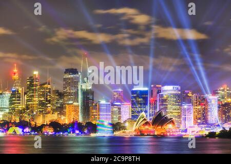 Waterfront of Sydney city high-rise towers and buildings on shores of Harbour at night during public light show. Stock Photo