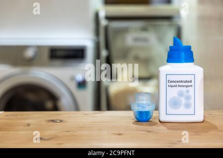 Innovative compact concentrated laundry liquid detergent against washing machine background at home Stock Photo