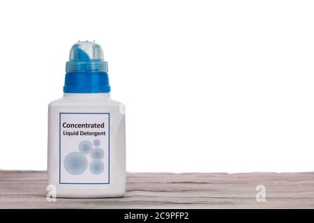 Tecnologically advanced compact concentrated laundry liquid detergent on wooden surface against white background Stock Photo