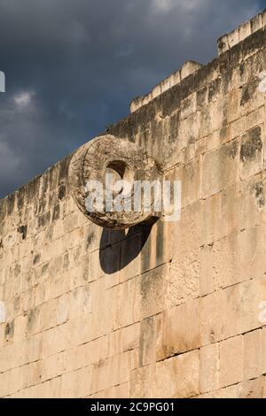 The carved stone ring set high in the wall of the Great Ball Court in the ruins of the great Mayan city of Chichen Itza, Yucatan, Mexico. Stock Photo