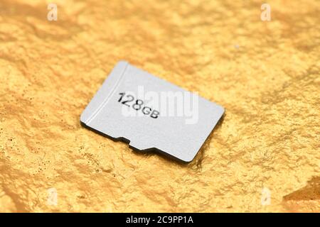SD memory card isolated on gold background. Soft-focus Stock Photo