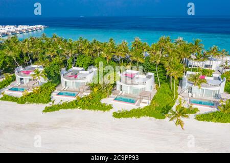 Perfect aerial landscape, luxury tropical resort or hotel with water villas and beautiful beach scenery. Amazing bird eyes view in Maldives, landscape Stock Photo