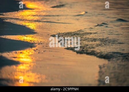 Sunset on the beach, abstract sea waves with foam Stock Photo