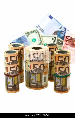 different denominations of banknotes in rolls and in bulk on a white background Stock Photo