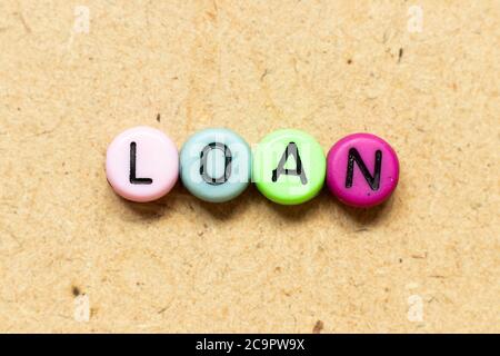 Round color bead with black letter in word loan on wood background Stock Photo