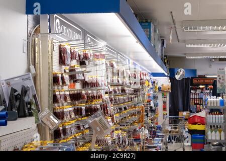Interior view of a general hardware and DIY store showing the various hardware items and tools on display. The section is well lit by tube down lights Stock Photo