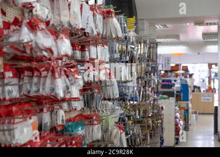 Interior view of a general hardware and DIY store showing the various hardware items and tools on display. The section is well lit by tube down lights Stock Photo