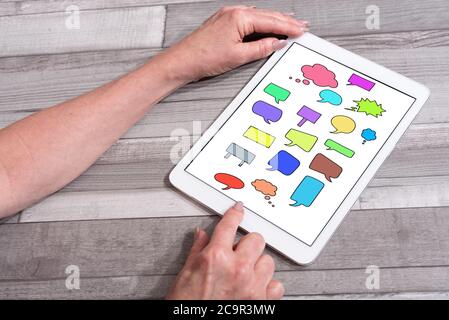 Communication concept shown on a tablet used by a woman Stock Photo