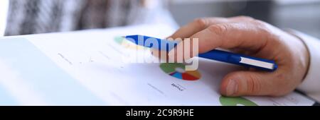 Male hands hold financial statement profit and pen Stock Photo