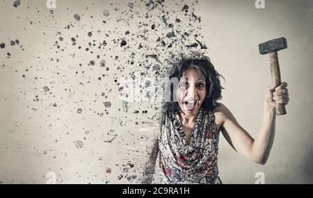 a Woman screaming with in hand a hammer dissolve Stock Photo