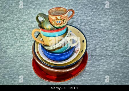 A small tower of high piled colourful crockery, bowls and cups Stock Photo
