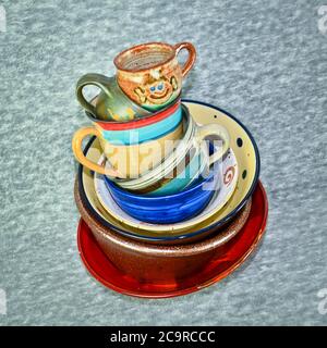 A small tower of high piled colourful crockery, bowls and cups Stock Photo