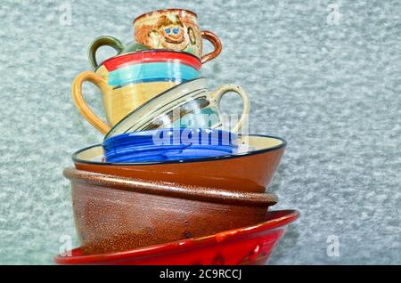A small tower of high piled colourful crockery, bowls and cups Stock Photo