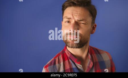 Smiling bearded young male model , dressed casually, lifting the eyebrow. Copy space. High quality photo Stock Photo