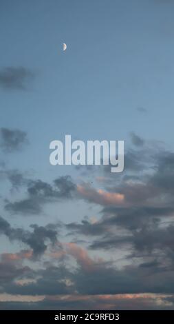 beautiful sunset clouds with crescent moon in the sky Stock Photo