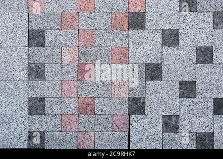 sidewalk stone, texture of a decorative stone for paving of sidewalks and roads.light gray with inserts dark gray and red. Stock Photo