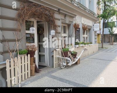 Czech Republic, Prague, Karlin, May 11, 2018: florist shop window, entrance decorated with dry birch tree branches flower pots nad baskets and white Stock Photo