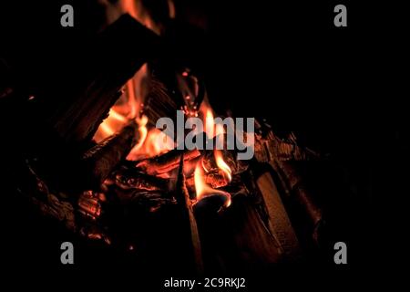 Log on fire burning billets in fireplace.Burning woods open fire background.selective focus.Barbecue Flaming Charcoal Grill With Bright Flames Of Fire Stock Photo