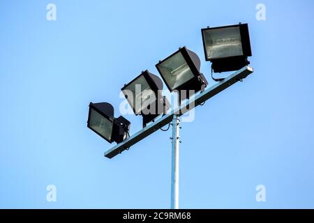 halogen spotlight on a column against the background of the sky, street lighting in the afternoon. Stock Photo