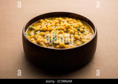 Ragda is the Indian curry made with dried white peas served in a bowl. It's flavorful, slightly tangy and spicy curry usually served with a potato cut Stock Photo