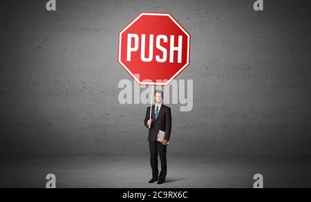 Young business person holding road sign with PUSH inscription, new rules concept Stock Photo