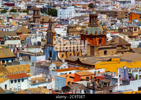 Aerial view of the historic district of Seville taken from the Giralda tower. Image features roof tops of vintage buildings and the decorative domed c Stock Photo