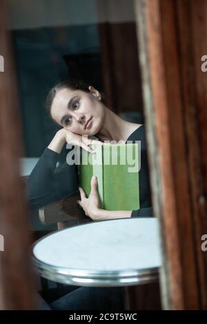 woman in coffee shop reading drinking cafe reading book Stock Photo