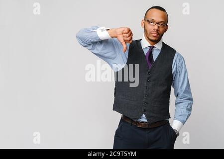 young black businessman with a dissenting serious dislike expression with thumbs down in disapproval Stock Photo