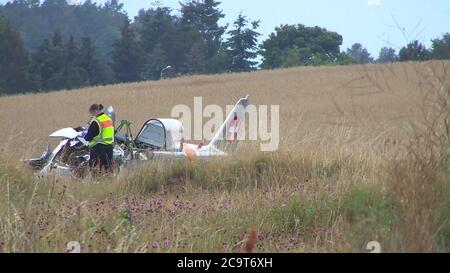 Heringsdorf Auf Usedom, Germany. 02nd Aug, 2020. A policewoman is standing at the wreckage of a crashed small plane. The pilot was killed when the single-engine Pilatus PC 2 plane crashed at the airfield from a height of about 40 metres, and another was recovered from the plane with serious injuries. The cause of the crash is being investigated by the criminal investigation department and the Federal Agency for Aircraft Accident Investigation in Braunschweig. Credit: Tilo Wallrodt/NonstopNews/dpa/Alamy Live News Stock Photo