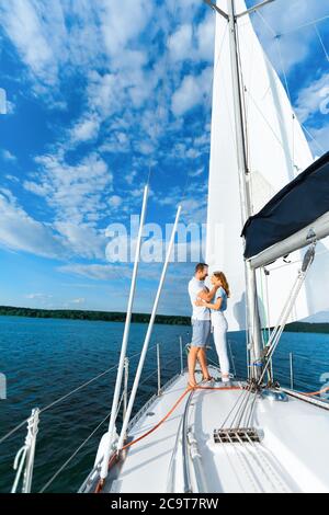 Couple On Yacht Hugging Sailing At Seaside, Enjoying Vacation, Vertical Stock Photo