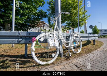 Ghost bike at guardrail. A ghost bike is a bicycle roadside memorial, placed where a cyclist has been killed or severely injured. Stock Photo