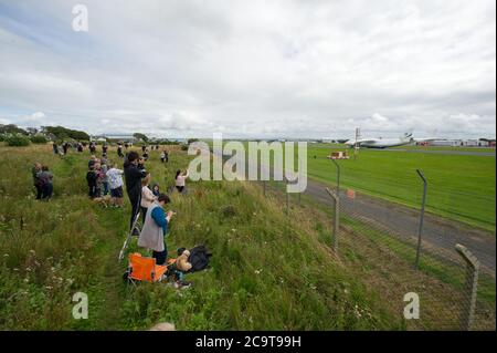 Prestwick, Scotland, UK. 2 August 2020 Pictured: Crowds of aviation enthusiasts and plane spotters turned out to see the Antonov An-225 Mryia (Reg UR-82060) make a scheduled arrival for a refeulling stop at Glasgow Prestwick Airport from Bangor, USA before departing at 4.30pm for Châteauroux-Centre Airport in France. The giant strategic airlift cargo plane behemoth is powered by six massive Six Ivchenko Progress Lotarev D-18T three shaft turbofan engines, has a maximum takeoff weight of 640 tonnes. Credit: Colin Fisher/Alamy Live News Stock Photo