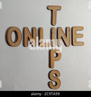 Online tips word presented on white surface with wooden cross text cloud frame art business learning background. Stock Photo