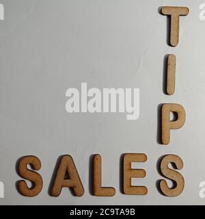 Sales tips word presented on white surface with wooden cross text cloud frame art business learning background. Stock Photo