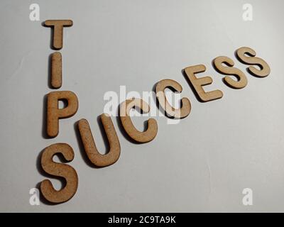 Success tips word presented on white surface with wooden cross text cloud frame art business learning background. Stock Photo