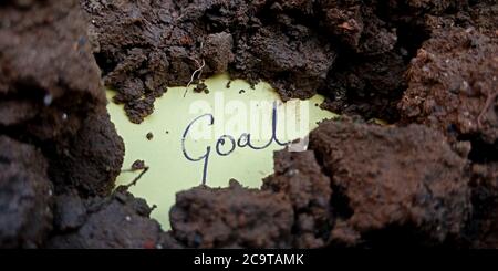 Goal word displaying on paper slip with black soil background business leadership concept. Stock Photo