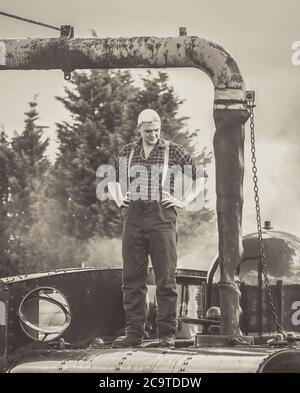 Steam train crew fireman filling water tank of vintage steam locomotive 7714, Severn Valley heritage steam railway, Kidderminster UK. Stock Photo