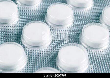 Macro shot pile of tablets pill in blister packaging. Silver aluminium foil blister pack. Pharmaceutical industry. Pharmacy products. Medicine pills a Stock Photo