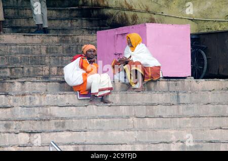 two sadhus sitting on stairs at varanasi ganga ghat Stock Photo
