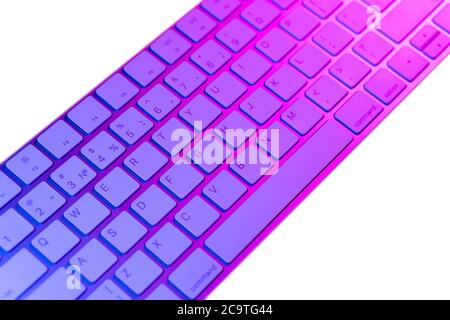 Close up view of a modern laptop computer keyboard keys. Soft lightning. Computer keyboard close up in pink and blue tones isolated on white backgroun Stock Photo