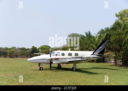 Close up of a small two-engine plane parked on a grass field, South Pantanal, Brazil. Stock Photo